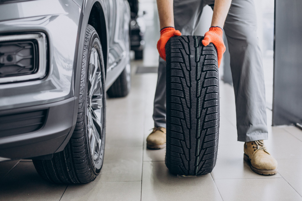 A man holding and changing cheap new car tyres online
